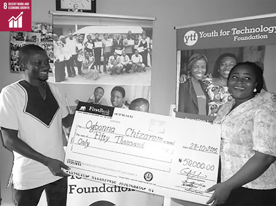 Photo Description:  Project 3E student, Chizaram, receives her seed capital to start a small business and hire other youth in her community.  